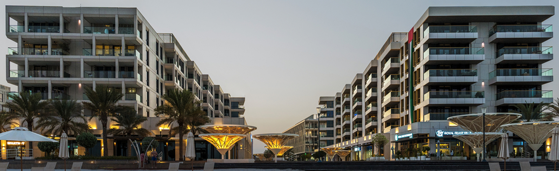 Waterfront apartments and retail promenade at dusk